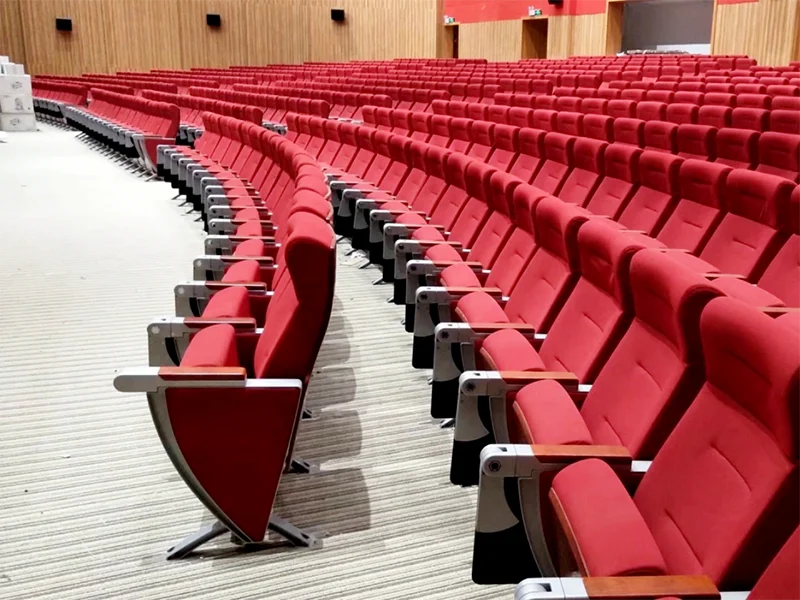 Wide armrest auditorium chair with shared armrest between two seats.