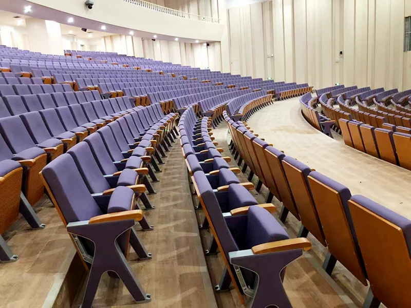 Auditorium chair with wider aisle arm for end of row installation.