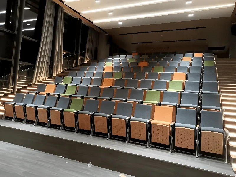 Auditorium chair with foldable writing tablet for lecture hall and exam room use.